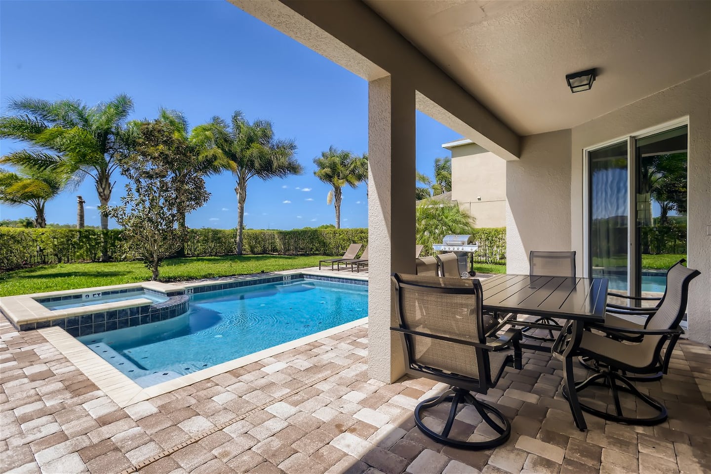 Magic Manor private pool and covered patio overlooking palm trees